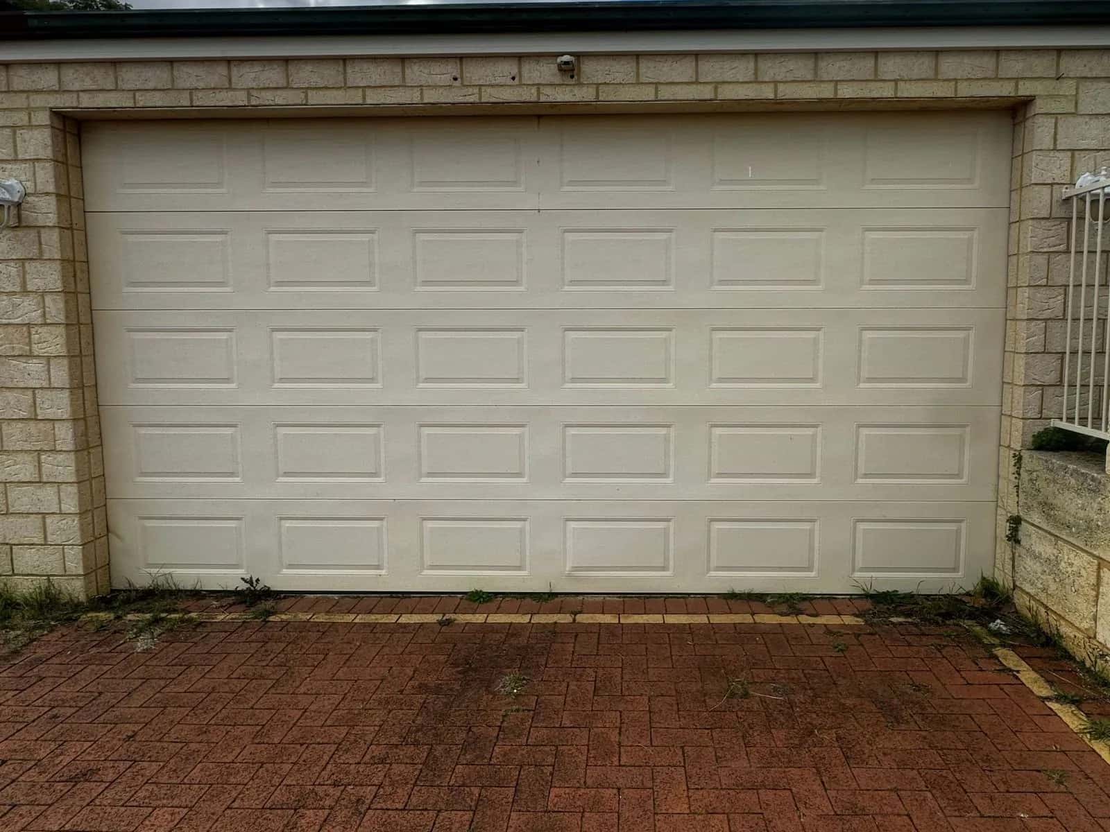 The same cream sectional door sitting level in its opening