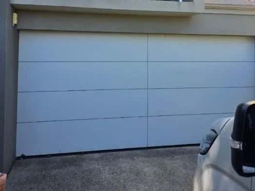 A new flush-panel sectional door closed in the same opening
