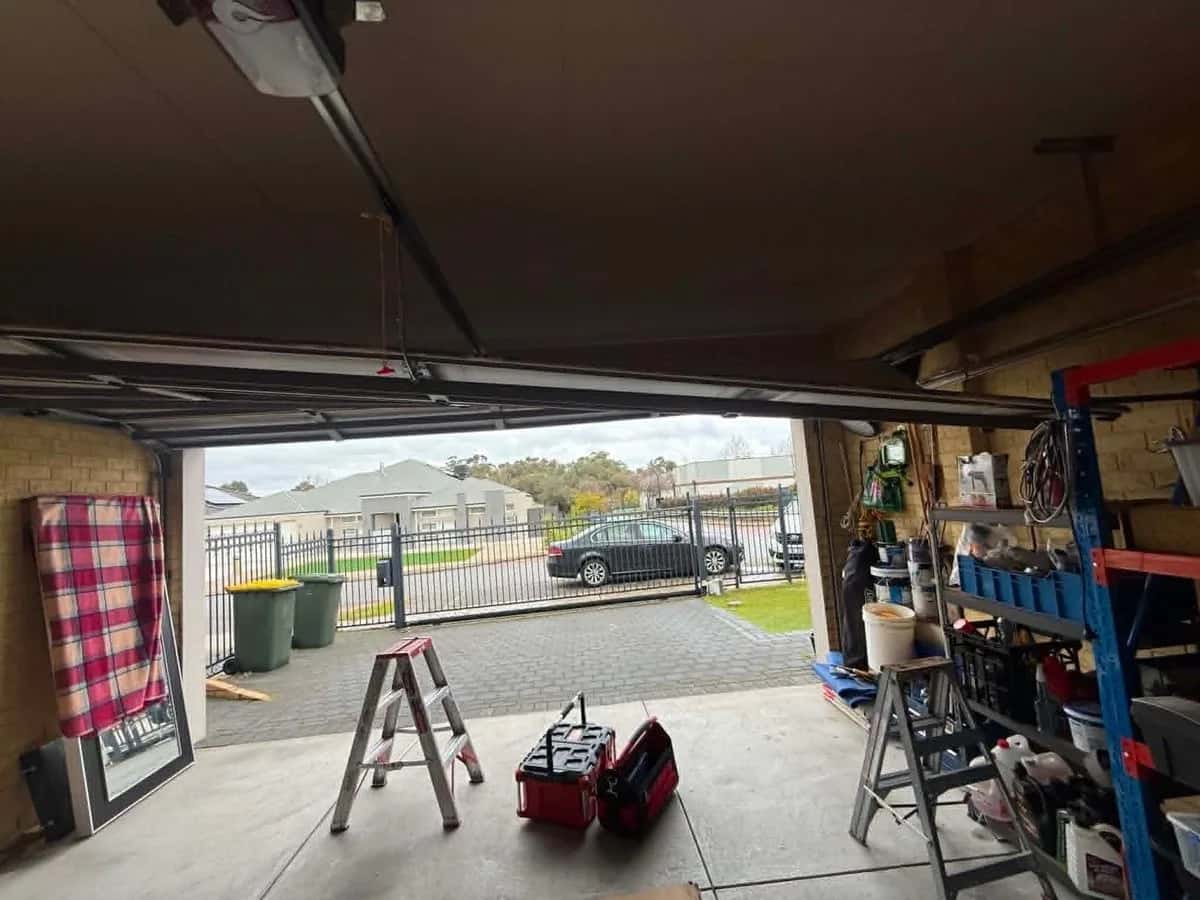 Looking up at a sectional door back on its track with the opener rail reconnected