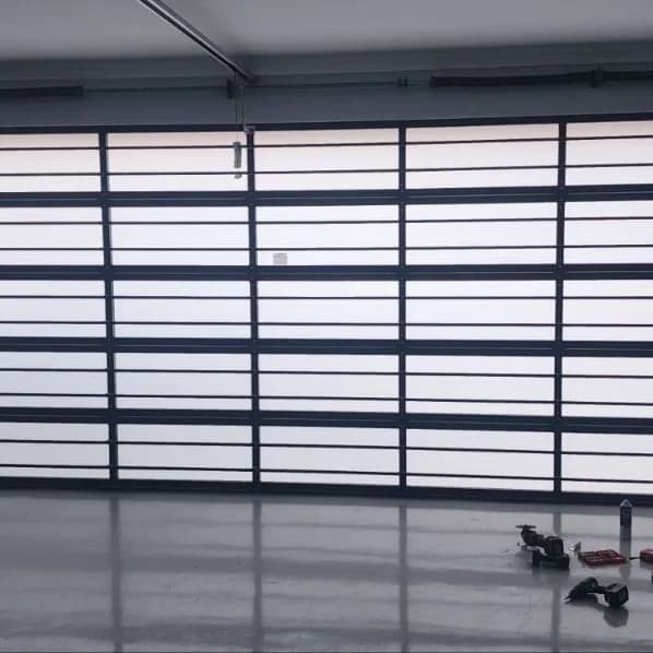 Daylight glowing through the frosted panels of a full-view glazed sectional door, seen from inside the garage