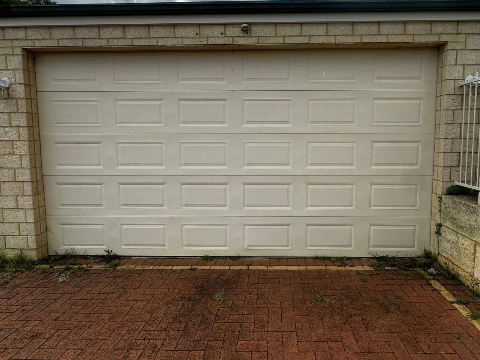 The same cream sectional door sitting level in its opening