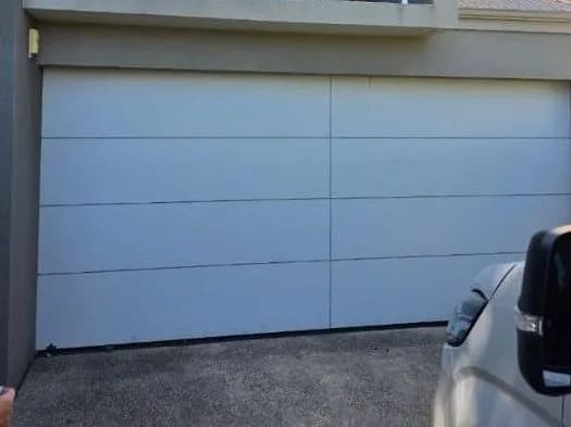 A new flush-panel sectional door closed in the same opening