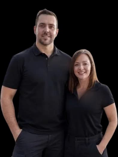 The owner and a team member standing together in matching work polos