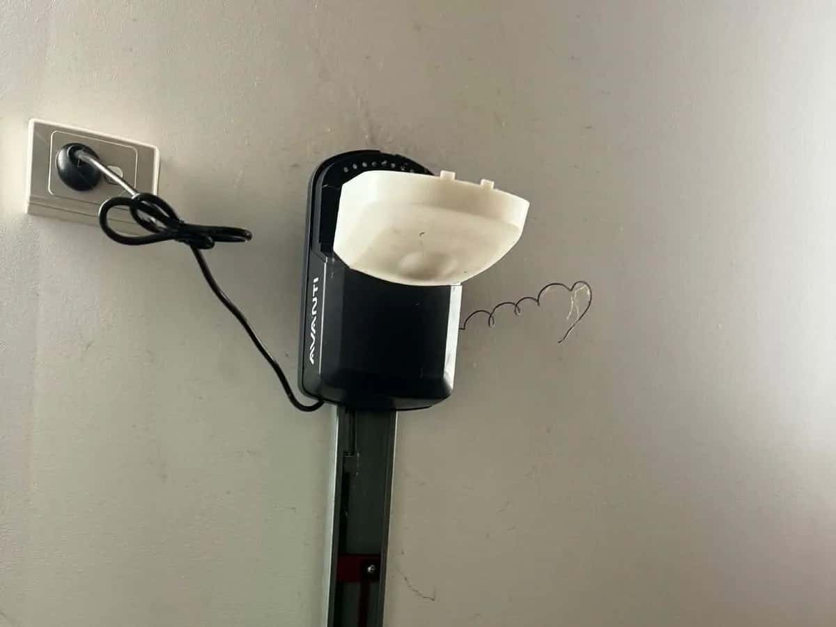 A ceiling-mounted opener with its light cover hanging open